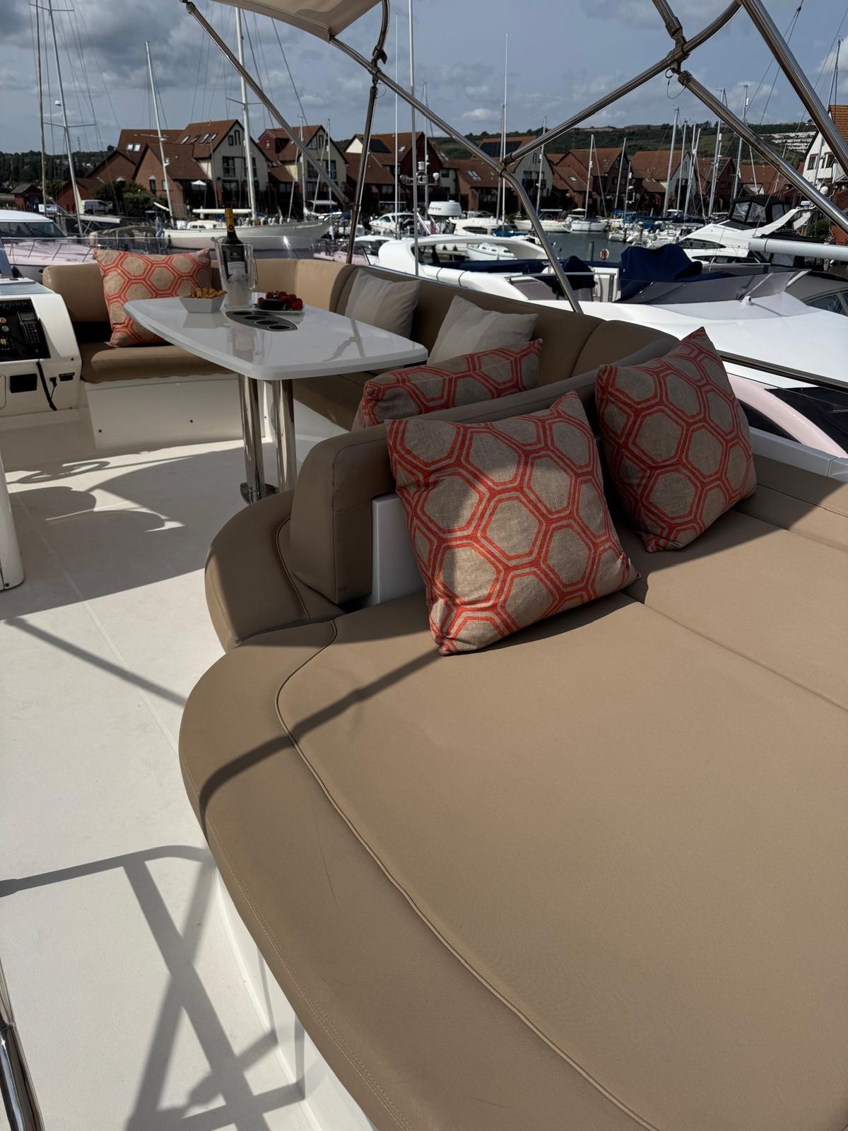 Flybridge featuring table seating alongside the skipper and a large, 3-4 person sunbed